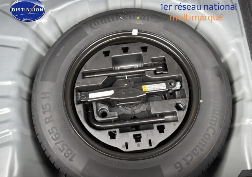 Vue plongeante sur la roue de secours et le kit de réparation dans le coffre d'une Renault Clio V noire 2026.