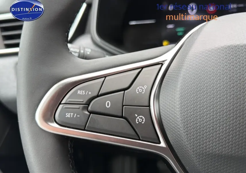 Gros plan sur les commandes de régulateur de vitesse au volant d'une Renault Clio V noire, intérieur moderne.