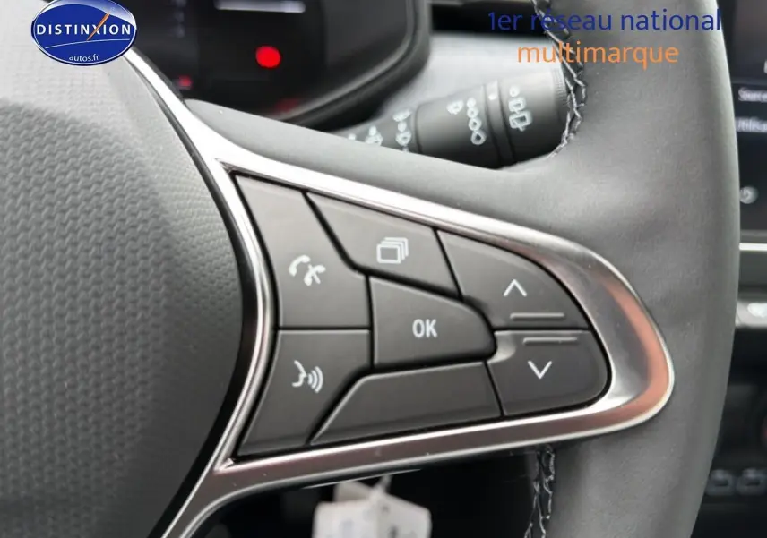 Gros plan sur les commandes multifonctions du volant cuir noir de la Renault Clio V 1.0 TCe 90 Evolution.