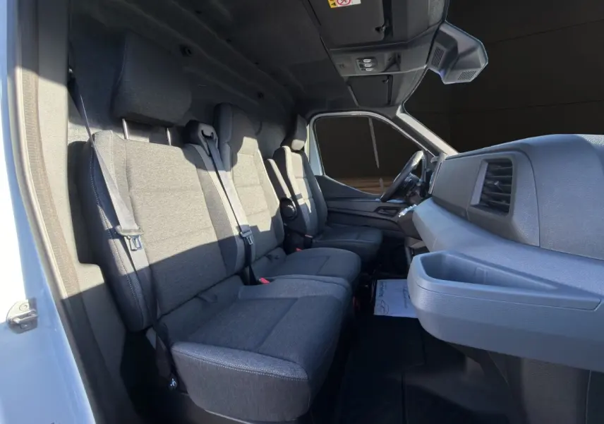 Vue intérieure côté passager du Renault Master blanc 2026, montrant les sièges gris et le tableau de bord moderne.