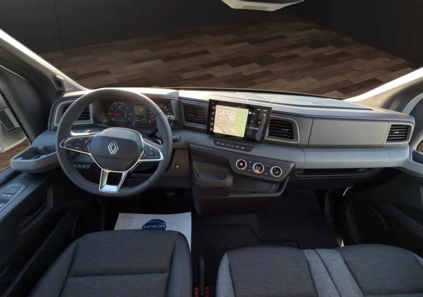 Vue intérieure avant du Renault Master 2026 avec tableau de bord gris, écran tactile central et volant multifonctions.