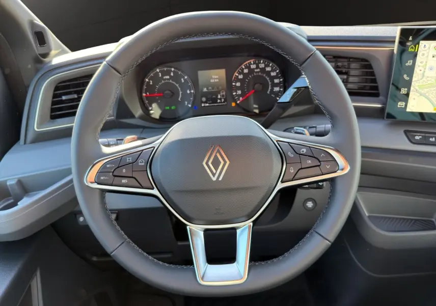 Vue rapprochée du volant noir du Renault Master 2026 avec tableau de bord et écran tactile de navigation visible.
