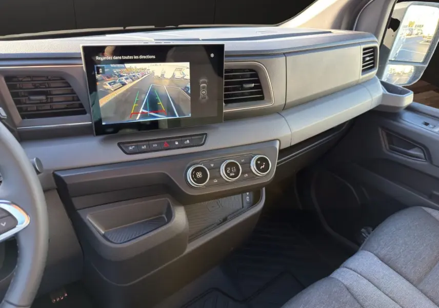 Vue intérieure côté passager du tableau de bord du Renault Master 2026 avec écran tactile et commandes de climatisation.