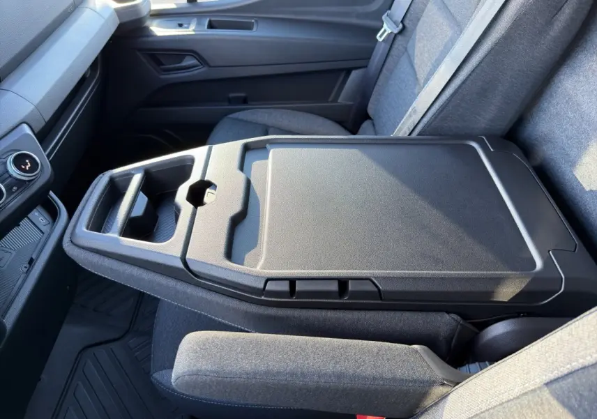 Vue intérieure rapprochée du siège passager gris avec tablette rabattable et porte-gobelets du Renault Master blanc 2026.