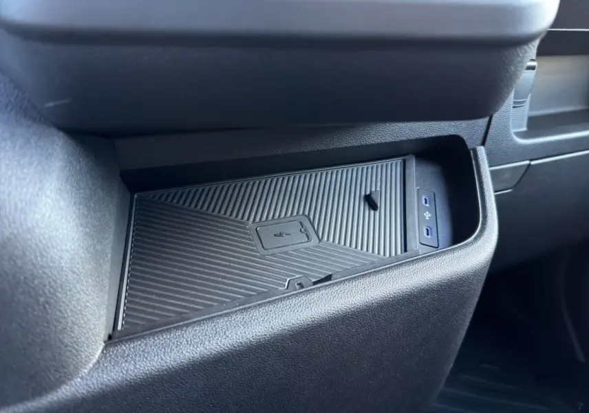 Gros plan sur le rangement réfrigéré noir dans l’habitacle du Renault Master blanc, avec ports USB visibles.