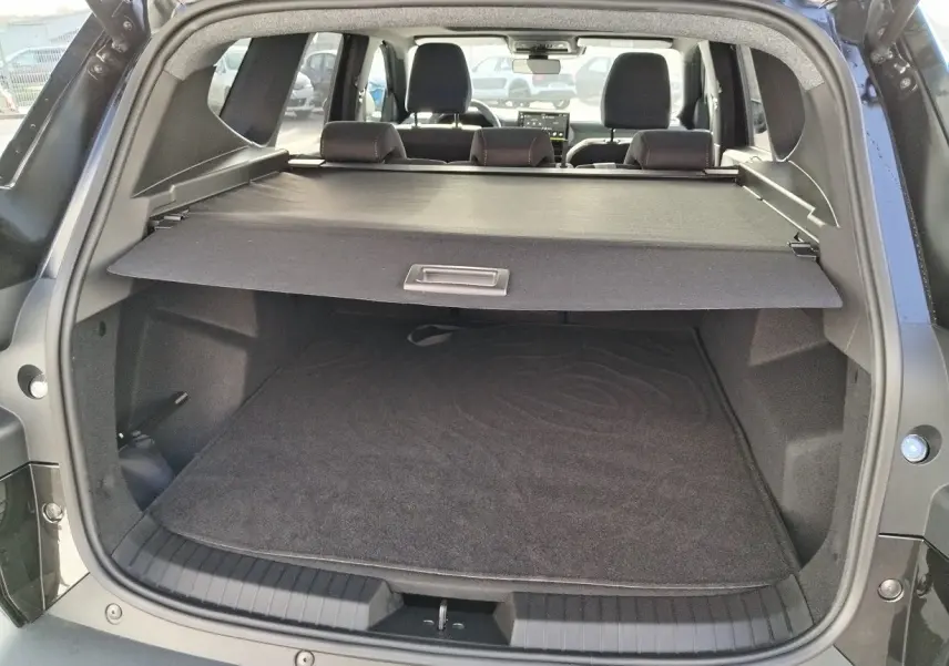 Coffre ouvert du Dacia Bigster noir 2025, vue arrière montrant la plage arrière et l'espace de chargement vide.