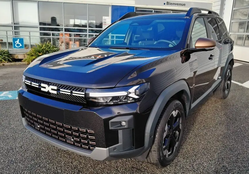 Vue 3/4 avant droite du Dacia Bigster noir 2025 avec calandre distinctive et jantes biton noires.