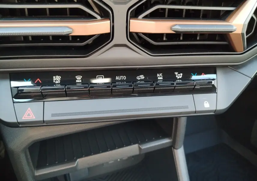 Vue rapprochée du tableau de bord noir du Dacia Bigster 2025, mettant en valeur les commandes tactiles de la climatisation.