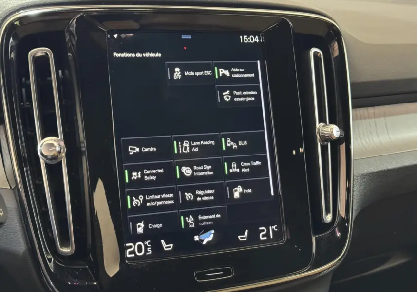 Écran tactile central affichant les fonctions du véhicule dans l'habitacle du Volvo XC40 noir, vue de face rapprochée.