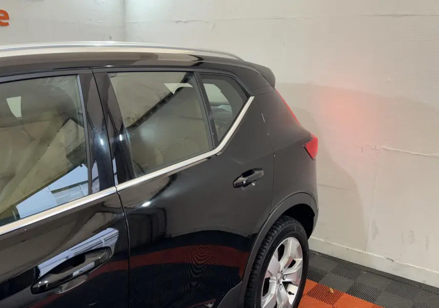 Vue latérale arrière droite d’un Volvo XC40 Recharge T5 noir, soulignant la ligne de toit et les jantes alliage.