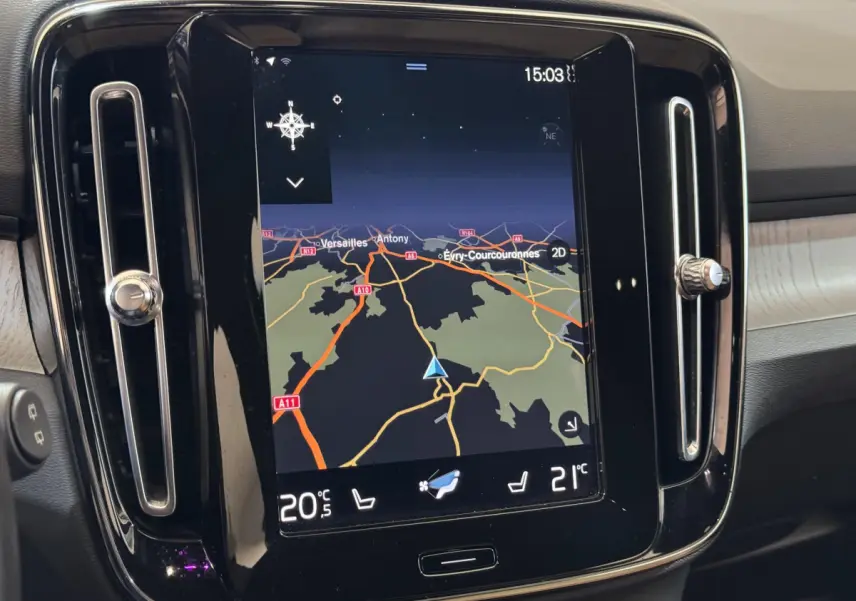 Écran tactile central du tableau de bord du Volvo XC40 noir, affichant la navigation et la climatisation.