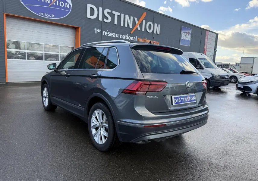 Volkswagen Tiguan gris Indium métallisé vu en 3/4 arrière droit, avec feux arrière LED et jantes alliage 18 pouces.