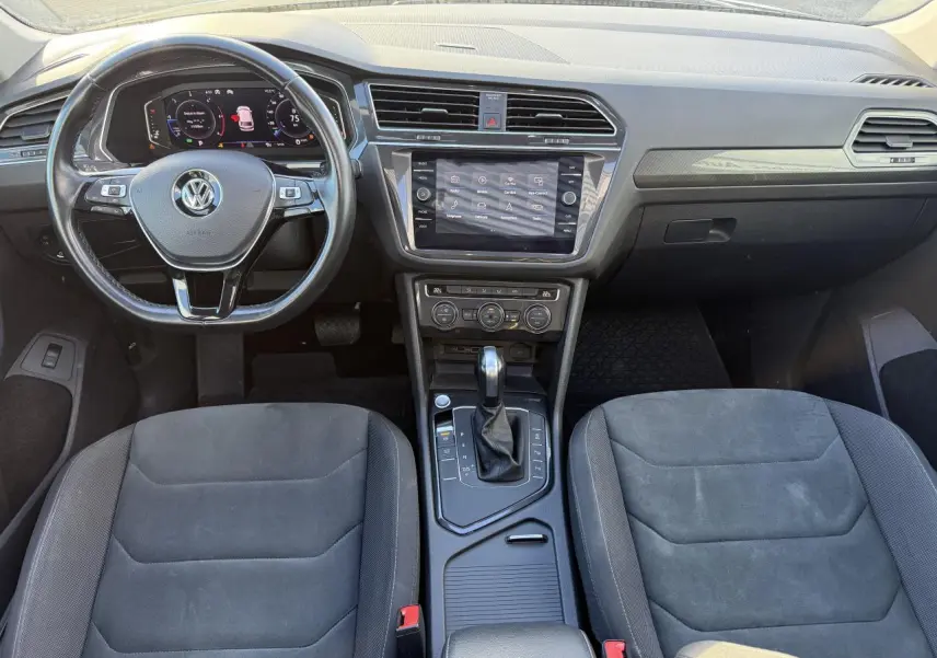 Intérieur du Volkswagen Tiguan 2020 en vue frontale, montrant le volant multifonctions et la console centrale noire.