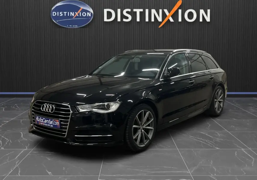 Audi A6 Avant noire vue en 3/4 avant droit dans un showroom avec jantes alliage et calandre chromée.