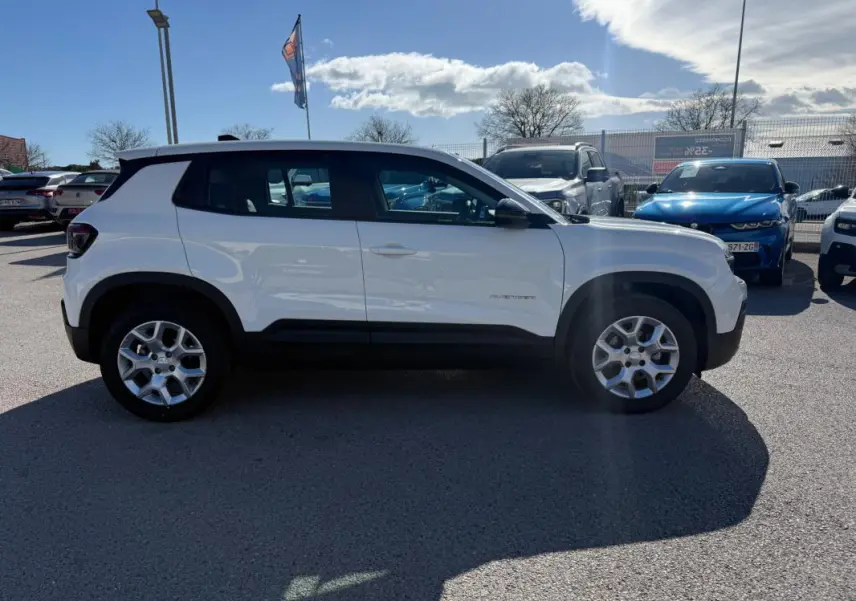 Vue de profil côté gauche d’un Jeep Avenger blanc avec jantes alliage 17 pouces sur parking extérieur.