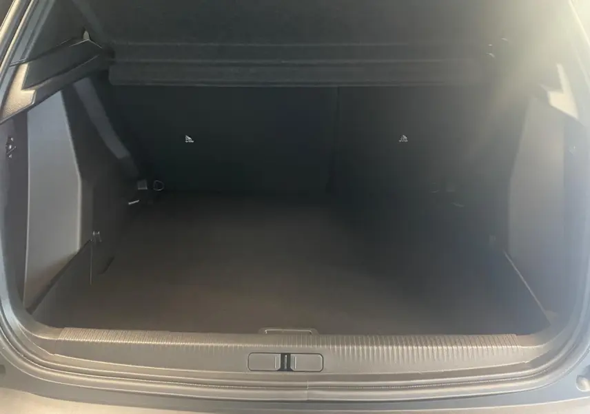 Coffre ouvert vu de face du Peugeot 2008 gris, montrant un espace de chargement vide et propre.