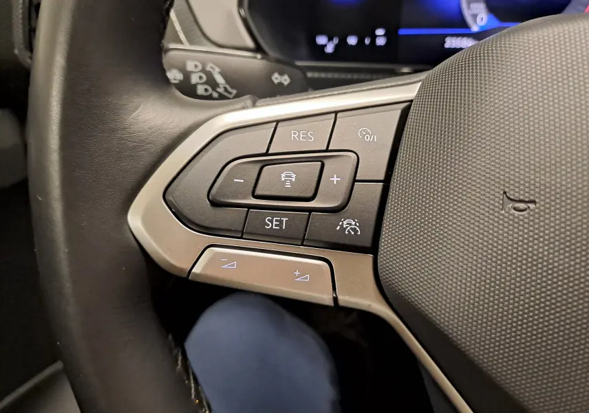 Gros plan sur les commandes au volant à gauche du Volkswagen T-Cross gris Ascot, version 2024 essence manuelle.