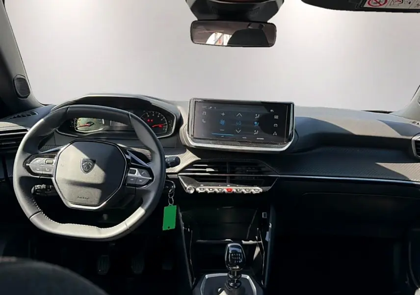 Intérieur de la Peugeot 2008 1.2 100 style 2025, vue frontale sur le tableau de bord et volant noir.