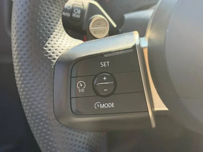 Gros plan sur les commandes de régulateur de vitesse au volant perforé noir du MINI Countryman argenté 2025.