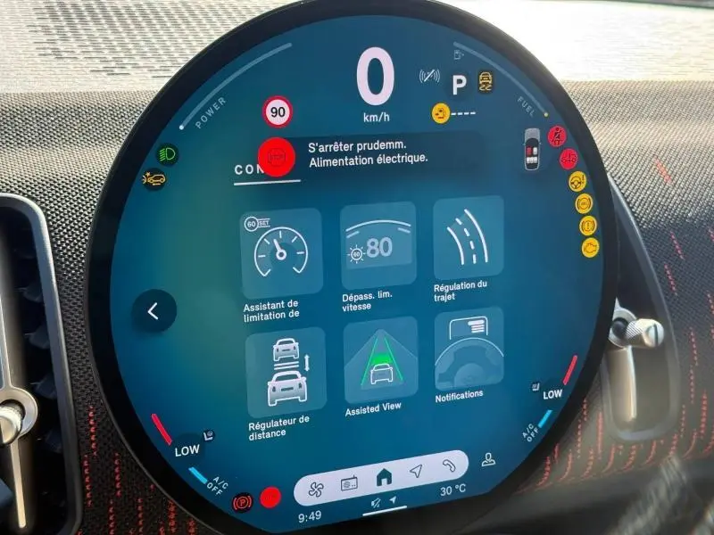 Gros plan sur l'écran circulaire multifonction du tableau de bord du MINI Countryman argenté, affichant les aides à la conduite.