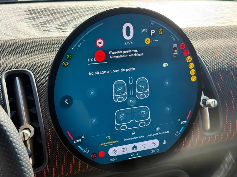 Affichage numérique circulaire du tableau de bord du MINI Countryman 2025, montrant les réglages d’éclairage et alertes.
