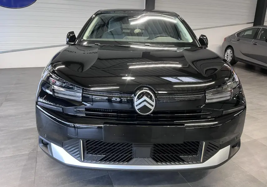 Vue frontale d'une Citroën C4 2025 noire métallisée avec calandre distinctive et détails argentés au pare-chocs.