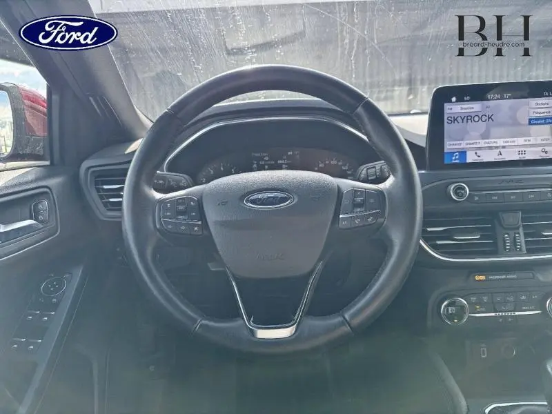 Vue centrée sur le volant cuir multifonction d'une Ford Focus 1.0 EcoBoost 2020 avec tableau de bord et écran tactile.