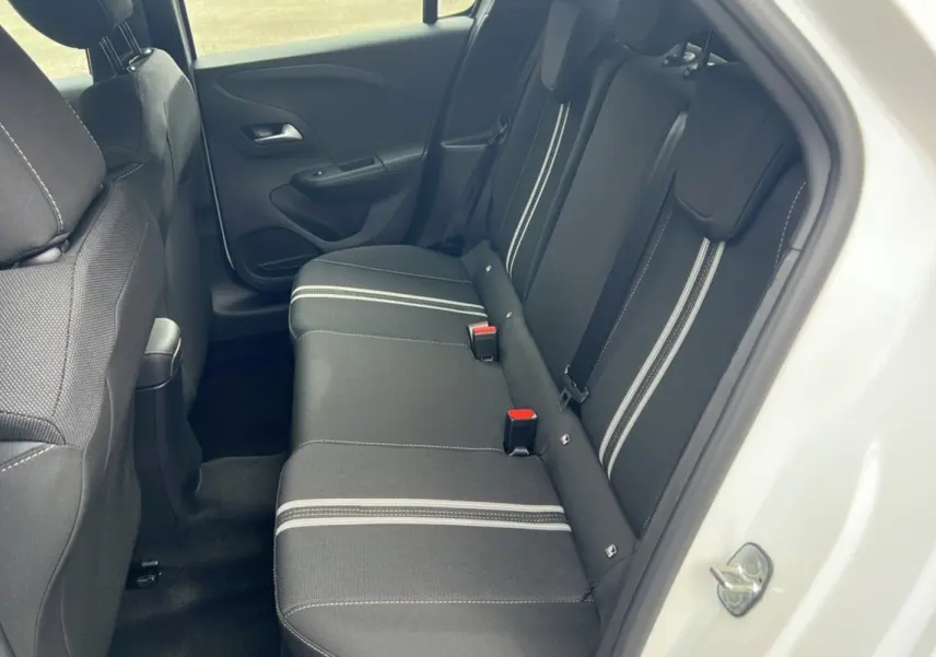 Vue intérieure côté droit sur la banquette arrière noire avec bandes blanches de l’Opel Corsa Hybrid blanc Kontur 2026.