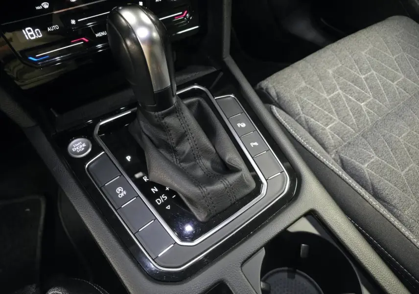 Gros plan sur la console centrale de la Volkswagen Passat SW 2023, levier de boîte auto et siège tissu gris.