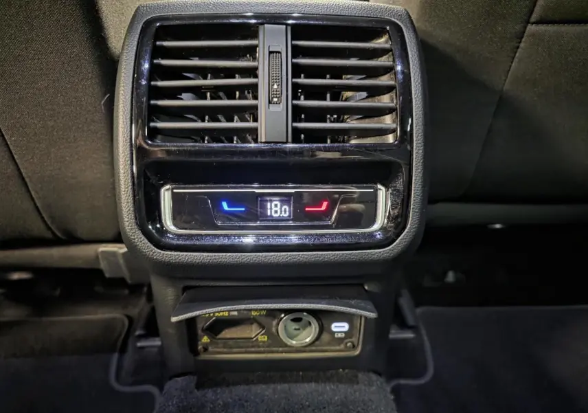 Détail de la console arrière noire de la Volkswagen Passat SW 2023 avec ventilation et réglage de température à 18°C.