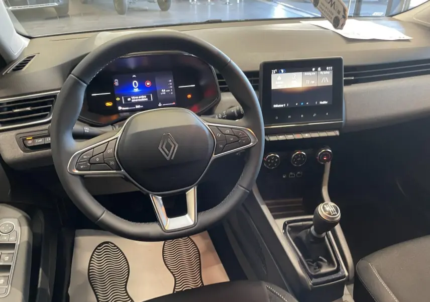Vue intérieure du poste de conduite de la Renault Clio 1.5 Blue dCi 2025 avec volant multifonction et boîte manuelle.