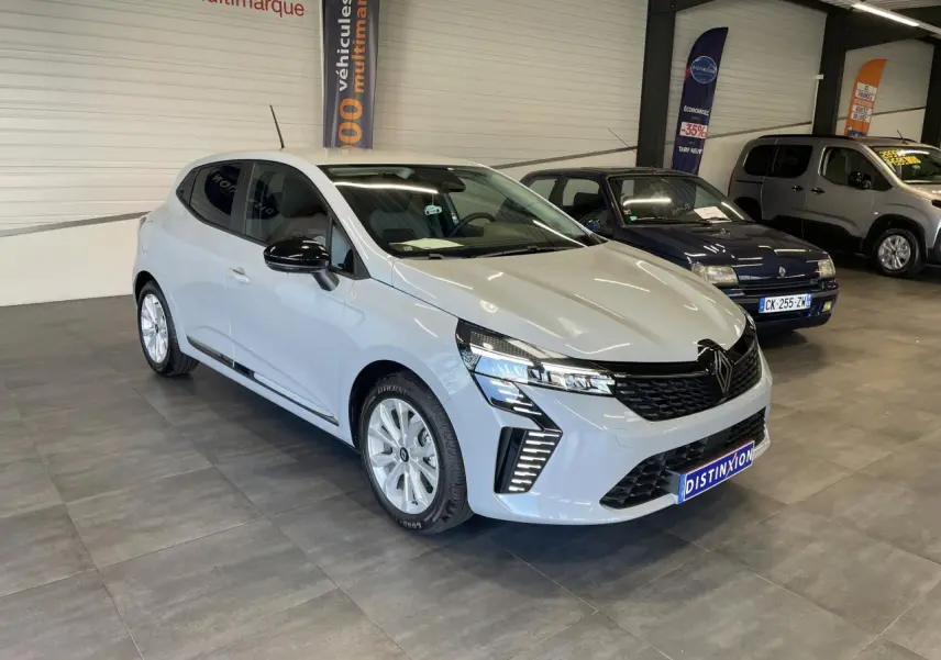 Renault Clio 2025 gris Rafale en 3/4 avant droit, avec calandre noire et feux LED distinctifs.