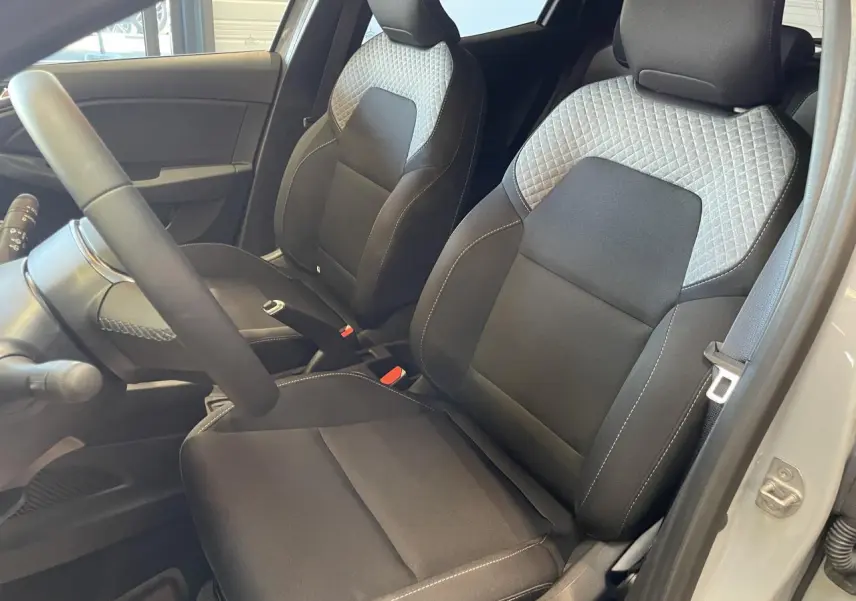 Vue intérieure côté conducteur de la Renault Clio 1.5 Blue dCi 2025 avec sièges tissu gris à motifs 3D twida.