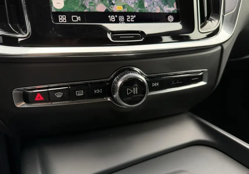 Gros plan sur la console centrale noire de la Volvo S60 2024, avec commandes multimédia et écran tactile visible.