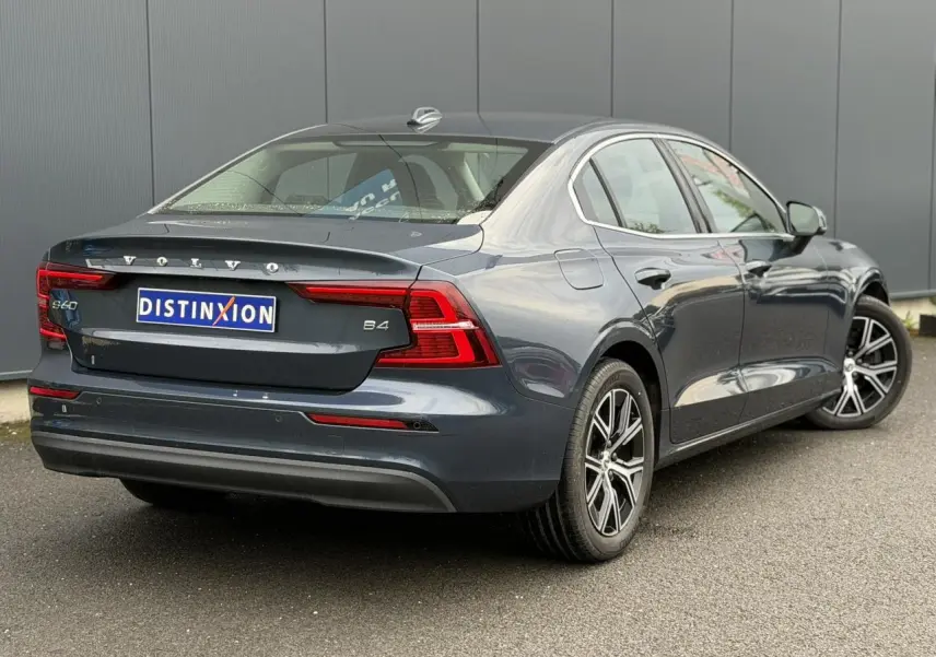 Vue 3/4 arrière droite d'une Volvo S60 B4 gris Denim avec jantes alliage 17 pouces et feux arrière LED.