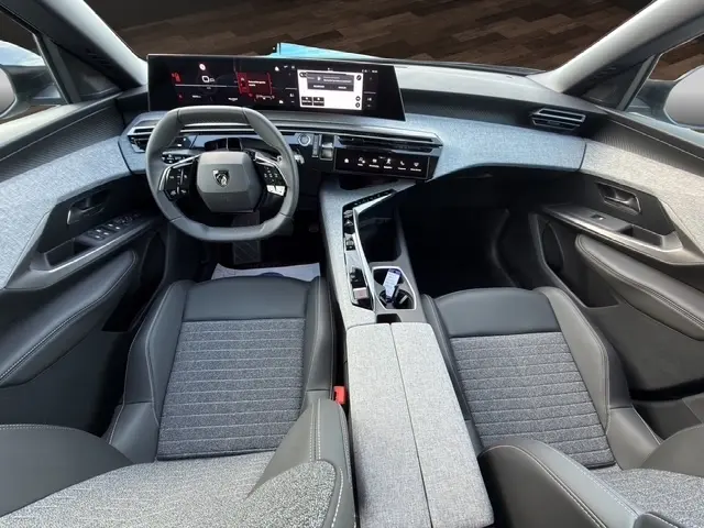 Vue intérieure avant du Peugeot 3008 1.2 Hybrid 145 Allure, montrant le tableau de bord numérique et les sièges gris et noirs.