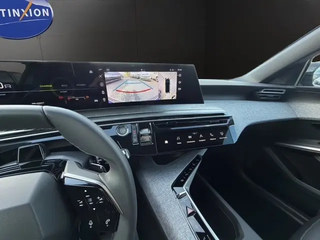 Vue intérieure côté conducteur du tableau de bord du Peugeot 3008 bleu 2026 avec écran multifonctions affichant la caméra de recul.