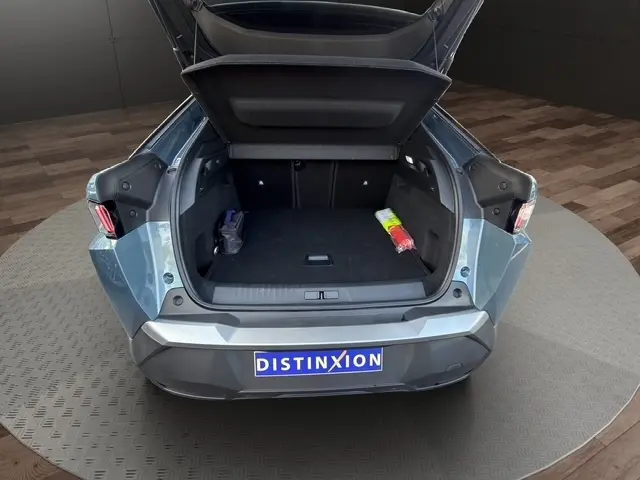 Vue arrière ouverte du coffre d'un Peugeot 3008 bleu 2026, montrant l'espace de chargement et les feux arrière LED.