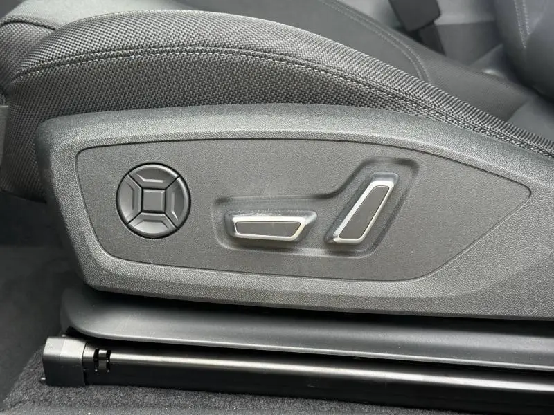 Gros plan sur les commandes de réglage électrique du siège conducteur de l'Audi Q3 2.0 TDI S line 2026, intérieur noir.