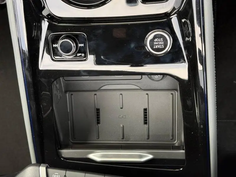 Vue rapprochée de la console centrale noire brillante de l'Audi Q3 2.0 TDI 150ch S line avec bouton start/stop et molette de contrôle.