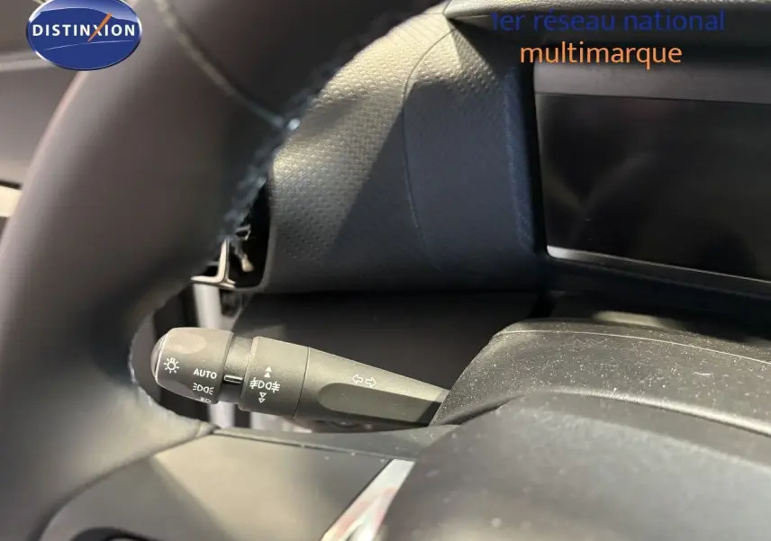 Le levier de clignotant noir du tableau de bord d'une Citroën C4 blanche essence 2022, vue intérieure.