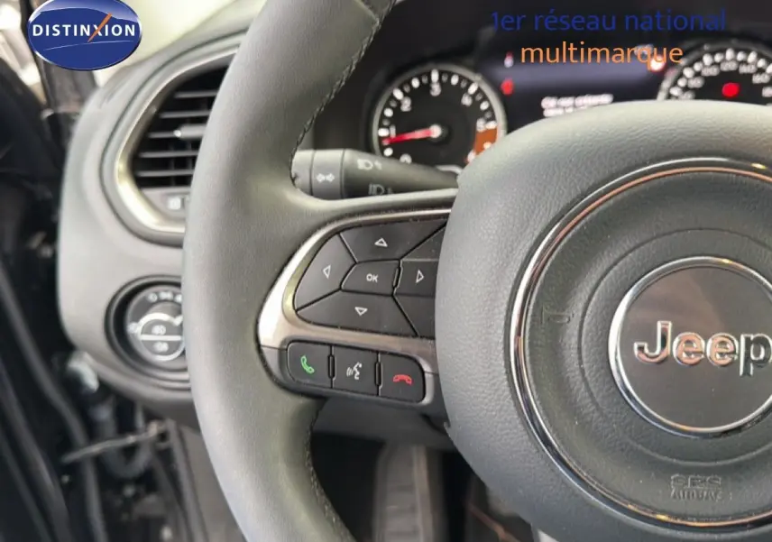 Vue rapprochée du volant noir de la Jeep Renegade 2022 avec commandes intégrées et tableau de bord partiel.