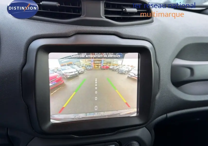 Écran central affichant la caméra de recul d'une Jeep Renegade noire, vue intérieure du tableau de bord.