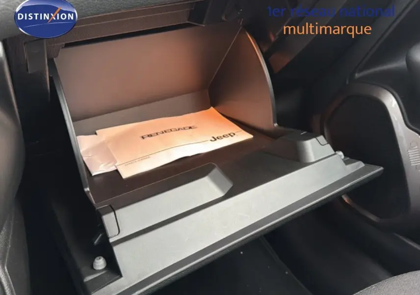 Gros plan sur la boîte à gants ouverte du Jeep Renegade 2022 avec manuel visible, intérieur noir.
