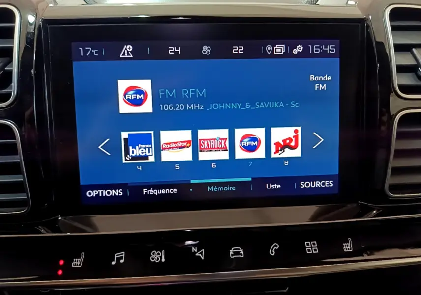 Écran tactile central du tableau de bord du Citroën C5 Aircross Hybrid noir, affichant les stations radio FM.