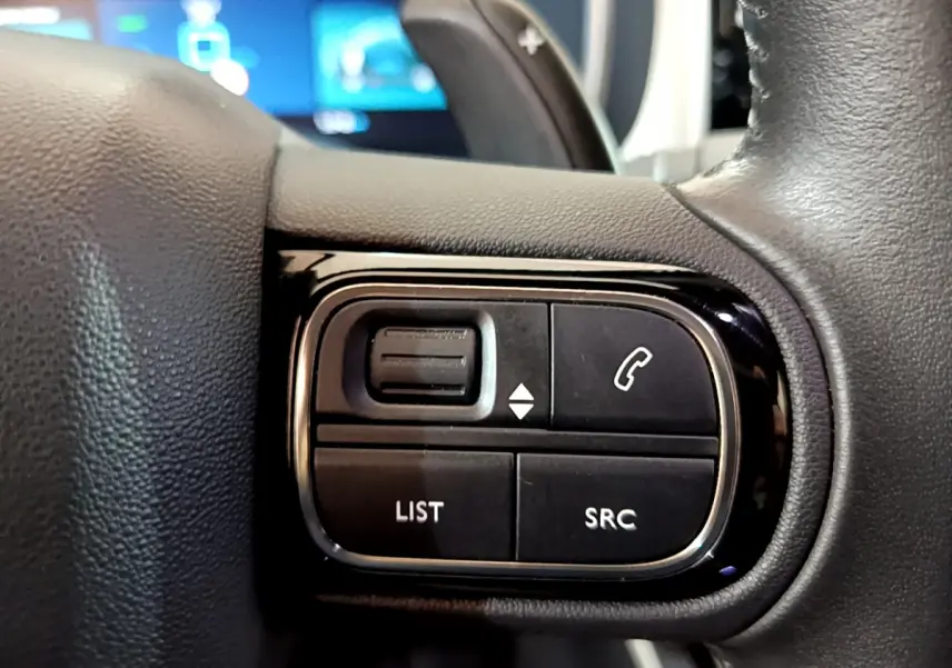 Gros plan sur les commandes gauche du volant cuir du Citroën C5 Aircross Hybrid noir, avec boutons appel et liste.