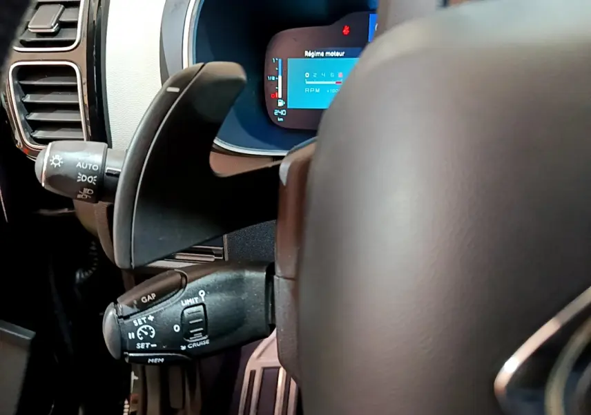 Gros plan sur le volant cuir et les commandes de régulateur de vitesse du tableau de bord numérique du Citroën C5 Aircross Hybrid noir.