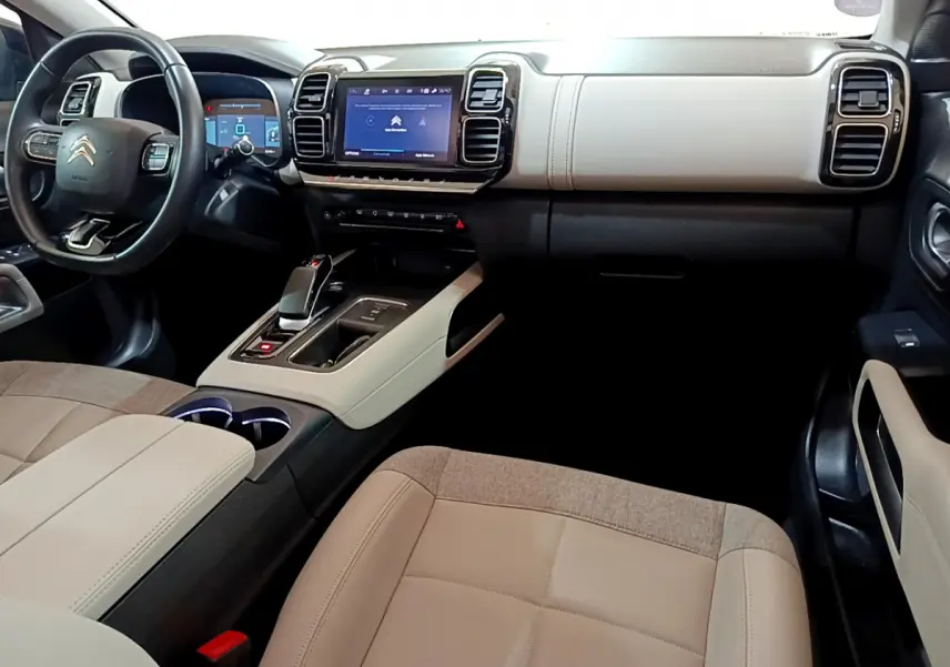 Intérieur clair du Citroën C5 Aircross Hybrid 225, vue côté passager avec tableau de bord et écran tactile central.