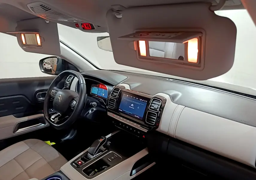 Intérieur du Citroën C5 Aircross Hybrid noir, vue côté conducteur sur tableau de bord et volant cuir multifonctions.