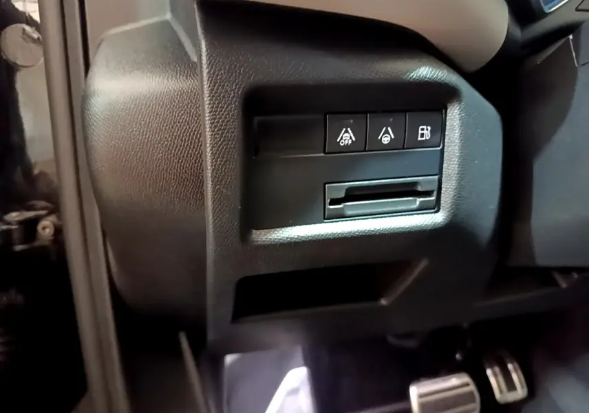 Gros plan sur les commandes de sécurité et assistance côté gauche du tableau de bord du Citroën C5 Aircross Hybrid noir.